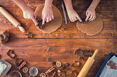 Young family making traditional gingerbread cookies for Christmas holidays