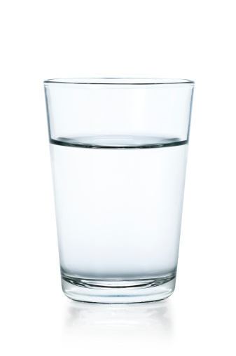 Vidrio transparente de agua sobre un fondo blanco photo