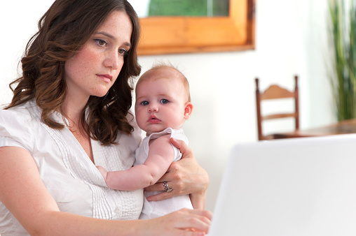 Mother working from home with baby looking stressed