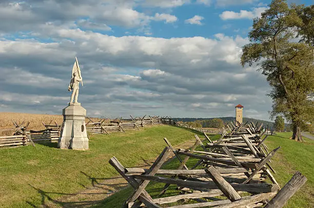 "Antietam National Military Park, Sunken Road and Bloody Lane fence line and memorial statue, Observation Tower in distance, Sharpsburg, MD, USA."
