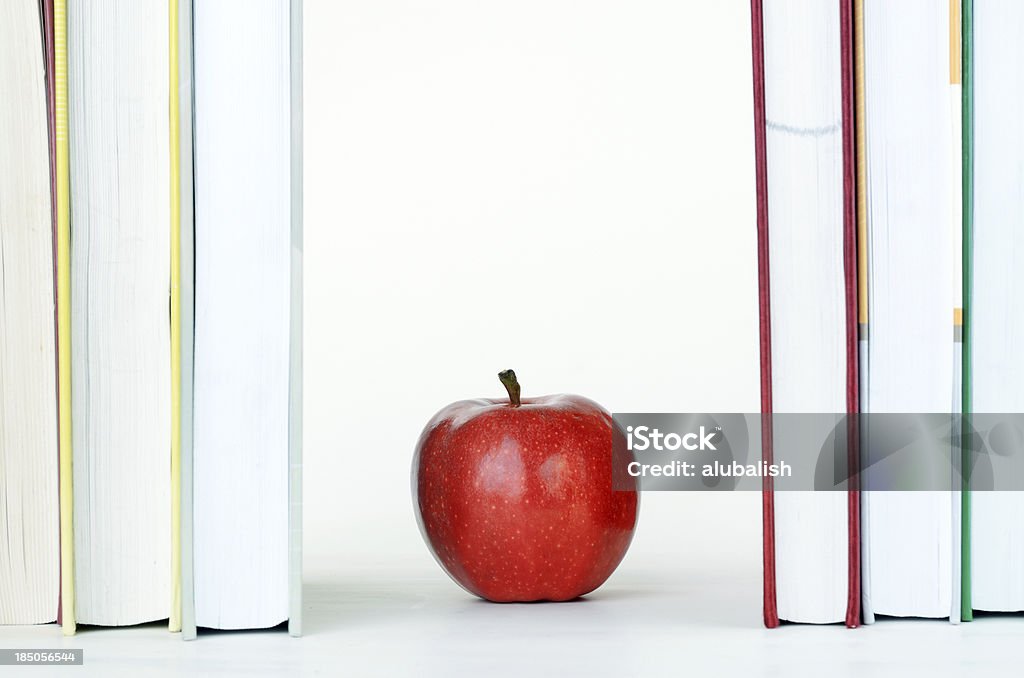Czerwone Jabłko na bookes - Zbiór zdjęć royalty-free (Białe tło)