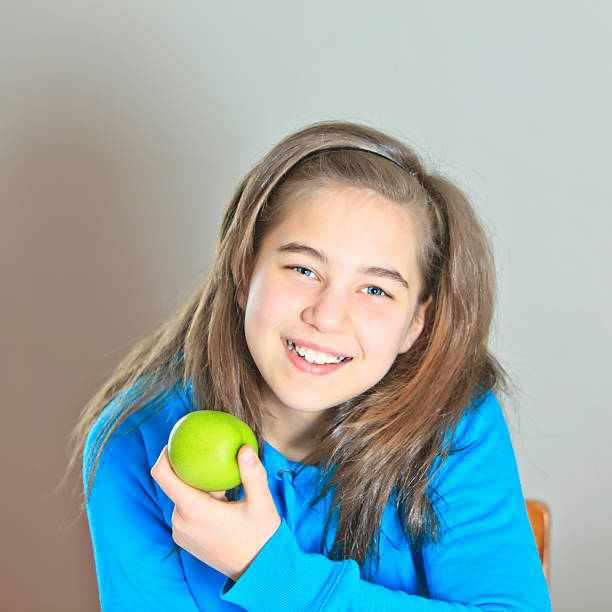 istock Smiling girl eating an apple 185057268