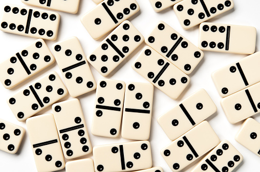 Scattered ivory domino pieces isolated on white background.