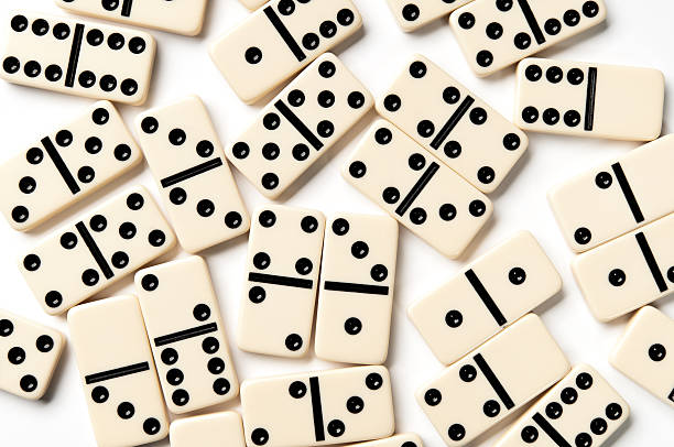 Scattered ivory domino pieces isolated on white background Scattered ivory domino pieces isolated on white background. domino stock pictures, royalty-free photos & images