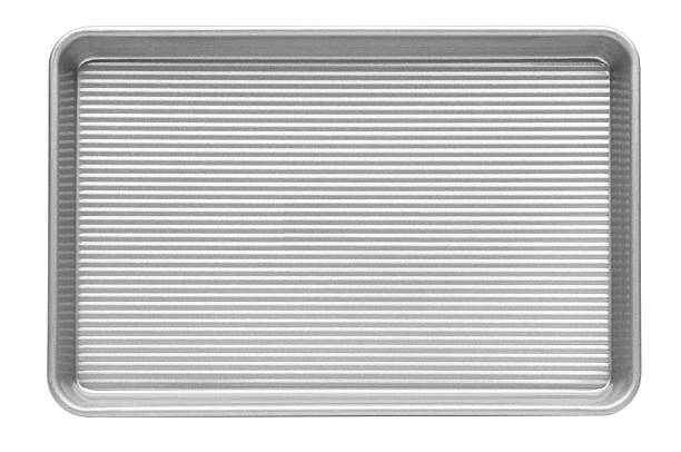 Ribbed aluminum cookie sheet on a white background stock photo