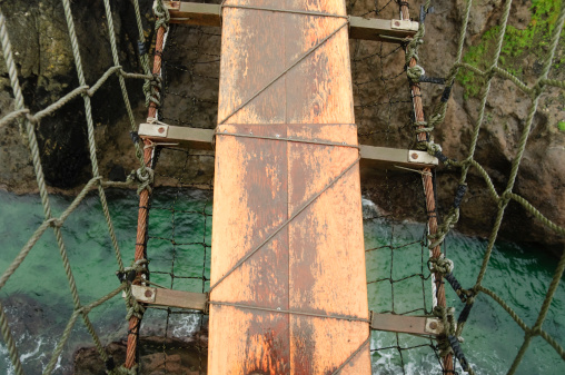 This is a detail of the famous Carrick-a-Rede Rope Bridge that links the mainland to the tiny Carrick Island. The site is owned and maintained by the National Trust, spans twenty metres and is thirty metres above the rocks below. Today the bridge is mainly a tourist attraction. The bridge is now open all year round.