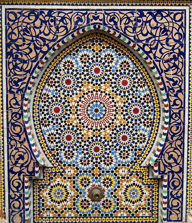 Traditional Moroccan fountain with mosaic tiles found outside a mosque in the souk of Rabat