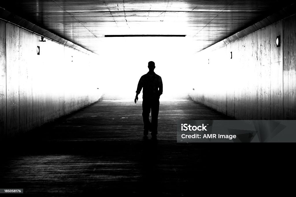 Tunnel suilhuette A man is walking out of the tunnel, black and white image.  Men Stock Photo