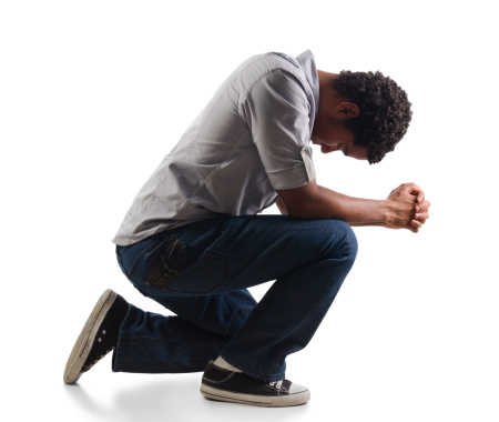 Young man praying on his knees
