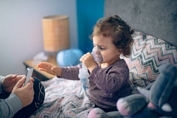 istock Mother helping her little daughter doing inhalation with a nebulizer 1850583756