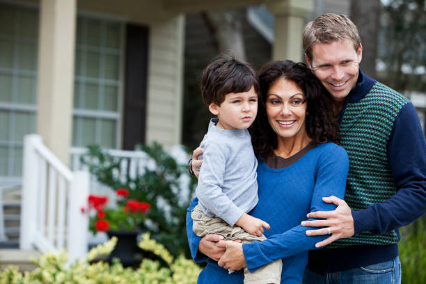 istock Family standing in front of house 185059463