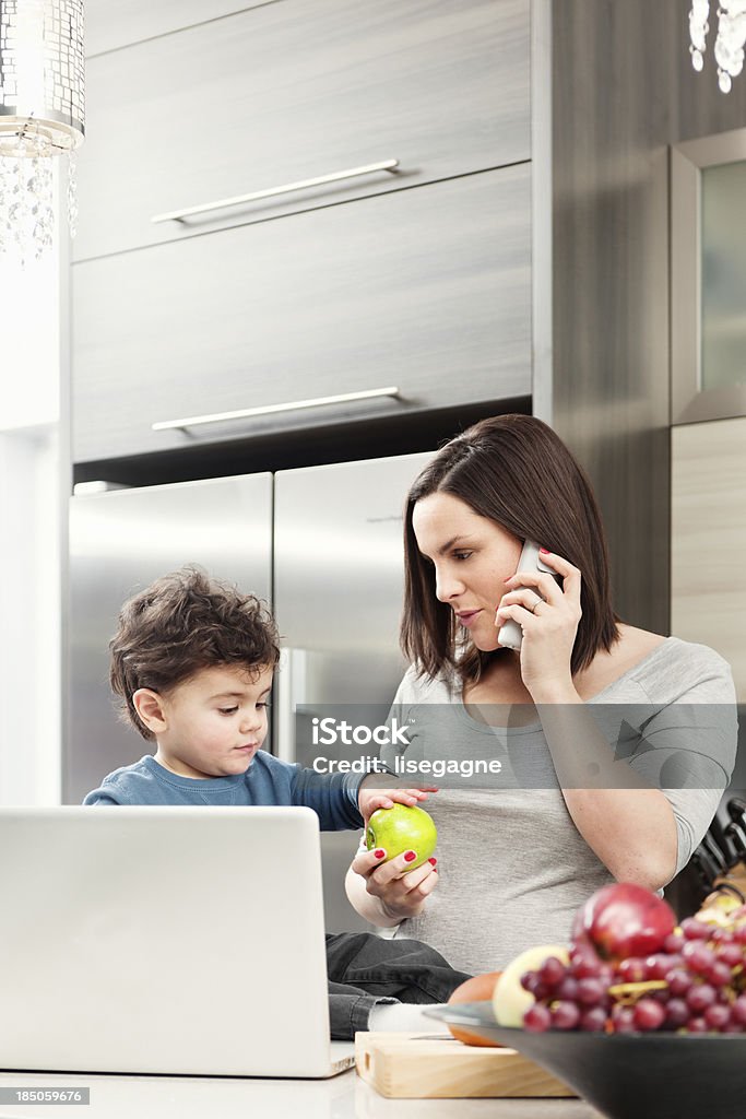 Pregnant woman with son in kitchen Pregnant woman with her kid in the kitchen 2-3 Years Stock Photo