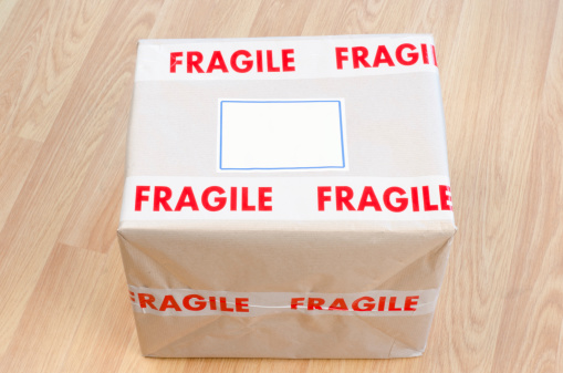 Fragile carton box with a blank shipping label - studio shot