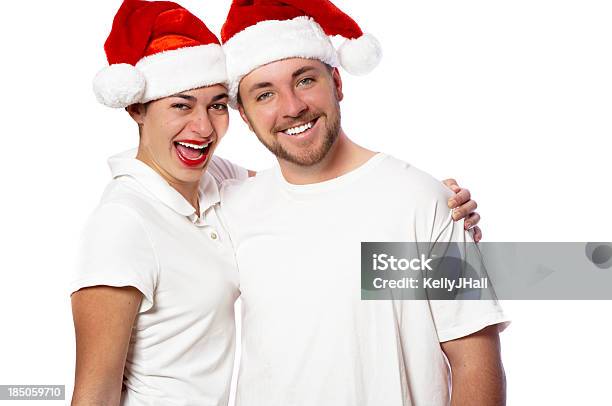 Photo libre de droit de Jeune Femme Et Homme Portant Chapeaux De Père Noël banque d'images et plus d'images libres de droit de Adulte - Adulte, Bonheur, Chapeau de Père Noël