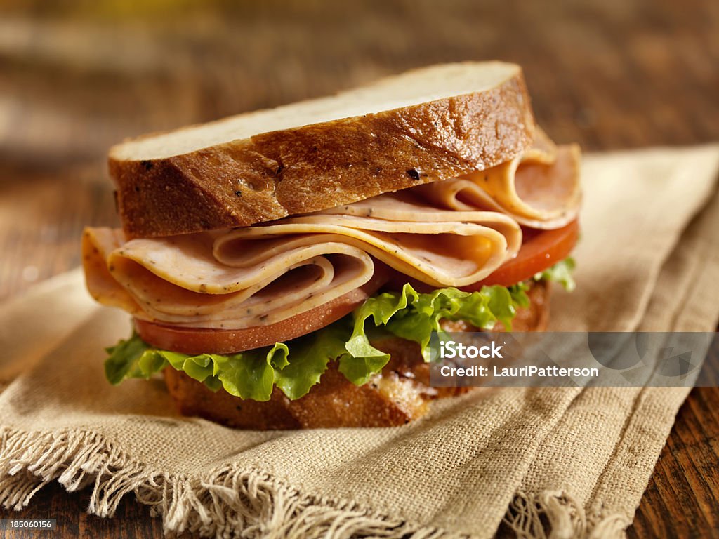 Turkey Sandwich Spicy Turkey Sandwich on Whole Grain Bread with Lettuce and Tomatoes  - Photographed on Hasselblad H3D2-39mb Camera Slice of Food Stock Photo