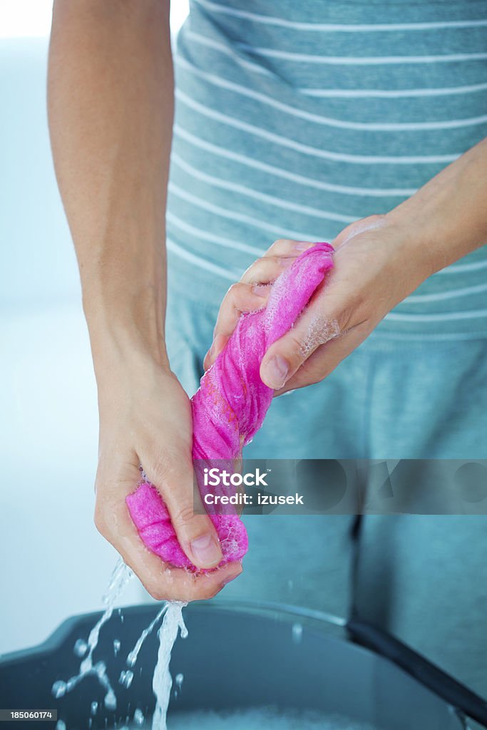 Wringing rag Woman wringing a cleaning rag under a bucket. Rag Stock Photo