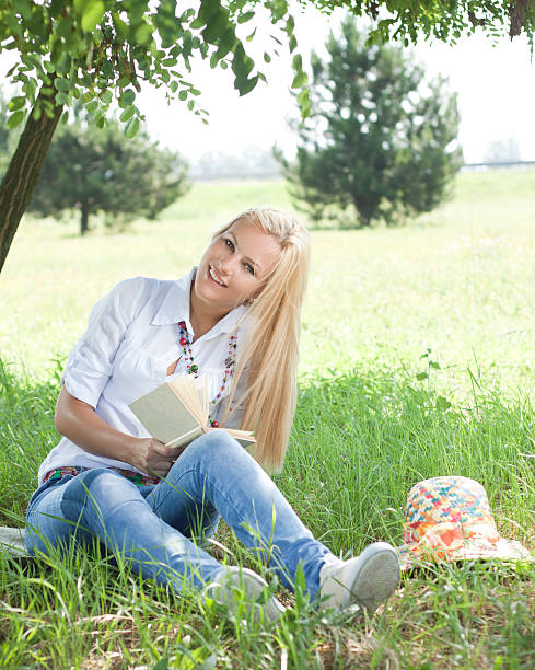 istock Young woman in park with book. 185060495
