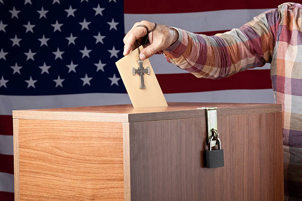 istock Man inserting poll envelope to ballot box before American Flag 185060520