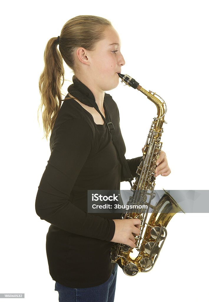 Одиннадцать лет девочка играет саксофон на белом фоне - Стоковые фото Саксофонист роялти-фри