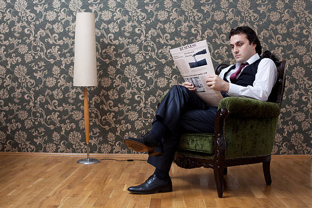istock Elegant businessman reading newspaper on sofa 185061515