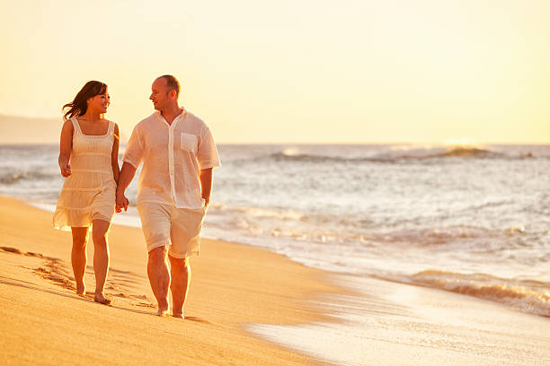 istock Happy Couple Walking on Hawaiian Beach at Sunset 185061552