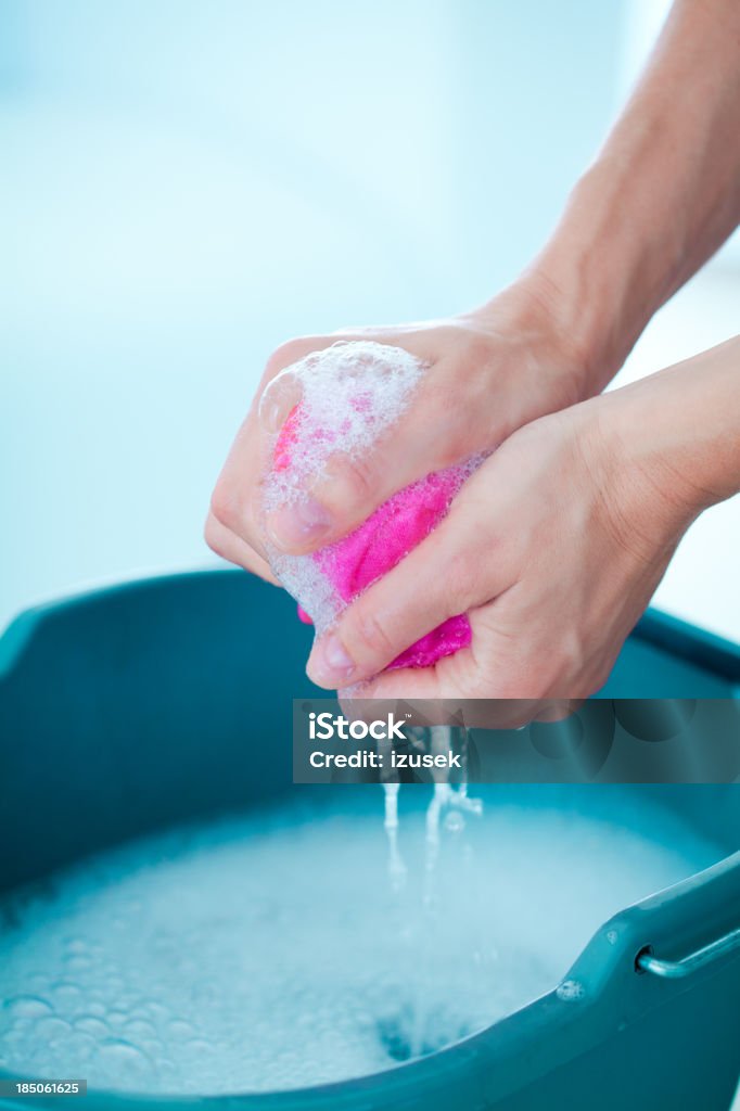 Wringing rag Woman wringing a cleaning rag under a bucket. Rag Stock Photo