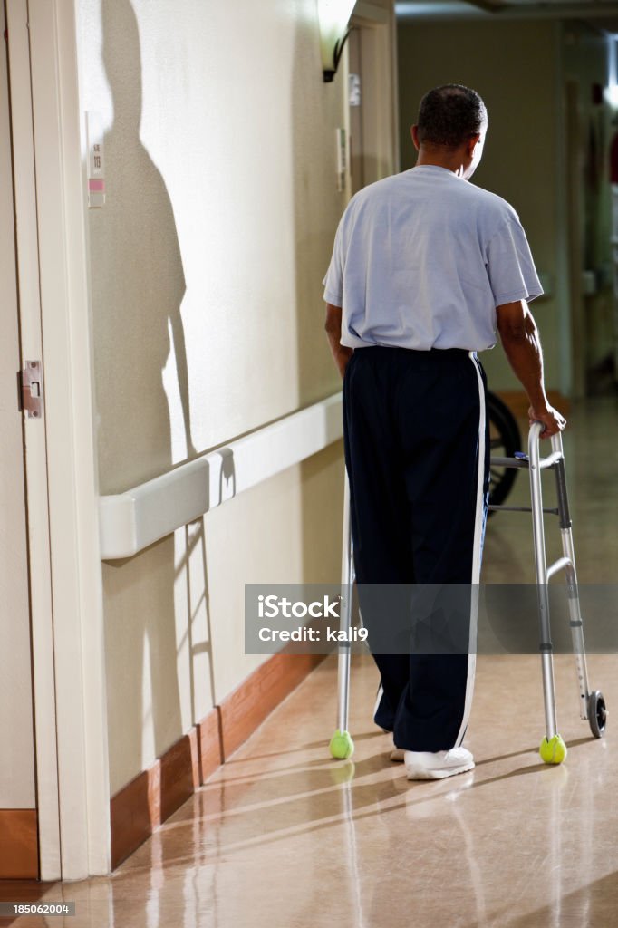 Starszy mężczyzna chodzić w korytarzu szpitala - Zbiór zdjęć royalty-free (60-64 lata)