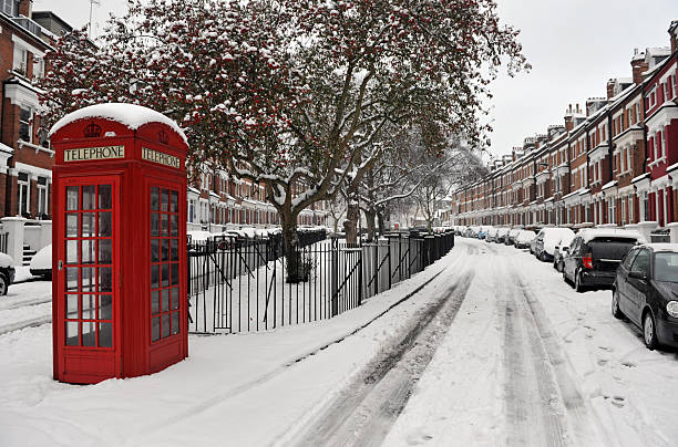 Snow and Phone box "A classic vintage red public telephone box in a London residential street - in the snowHampstead, London, UK" winter wonderland london stock pictures, royalty-free photos & images