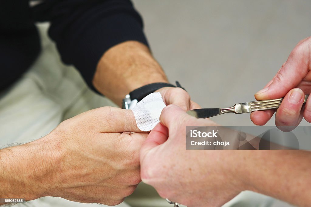 Enfermera en work.changing vendaje a una heridos paciente - Foto de stock de Aplicar libre de derechos