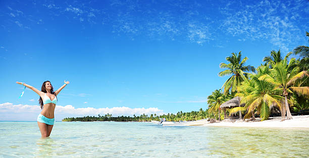 Carefree young woman relaxing on tropical beach panoramic stock photo