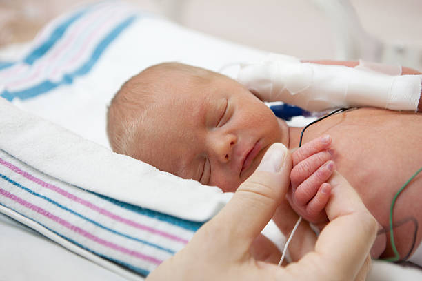 madre holdind mano di un neonato prematuro in incubatrice - premature foto e immagini stock