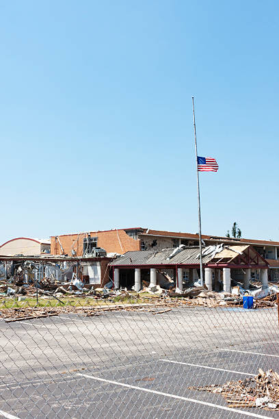 Flag Flies Outside a Tornado Damaged School stock photo