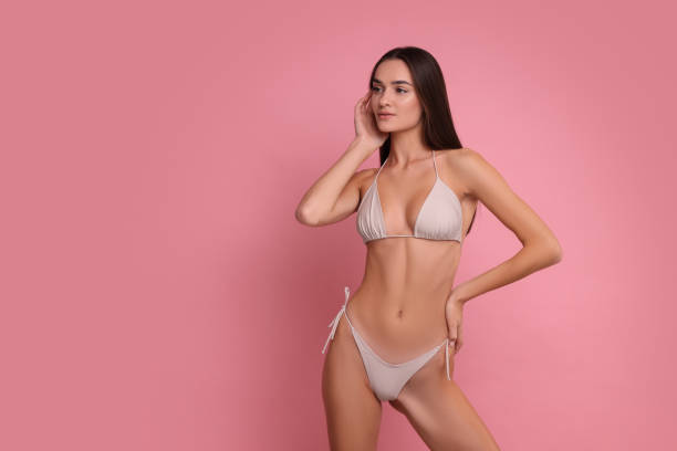 istock Young woman in stylish bikini on pink background, space for text 1850634748