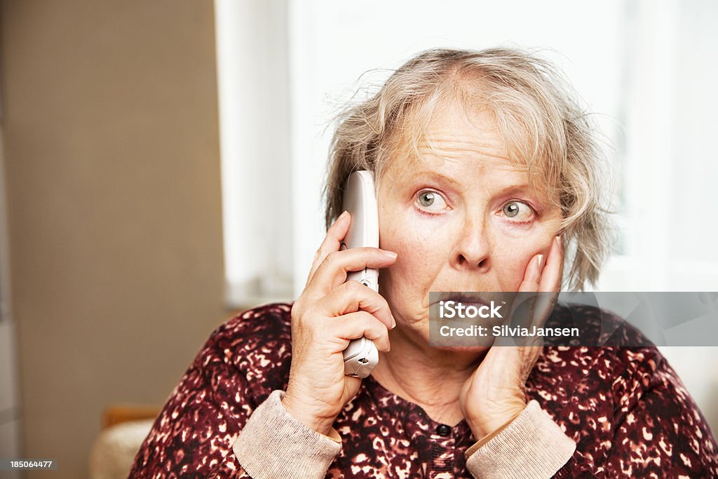 senior donna al telefono Preoccupato - Foto stock royalty-free di 55-59 anni