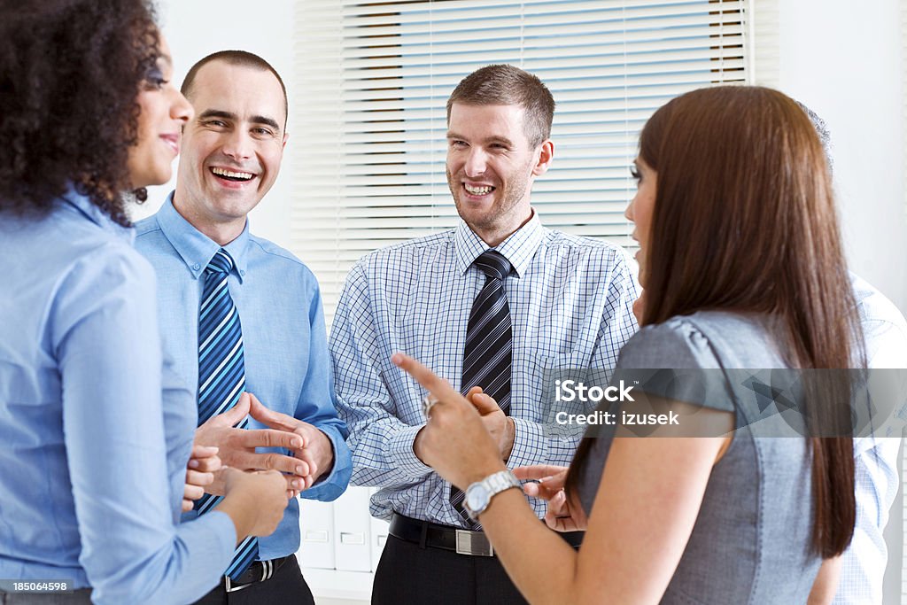 Business Team Five happy business people standing in an office and telling funny stories. 25-29 Years Stock Photo