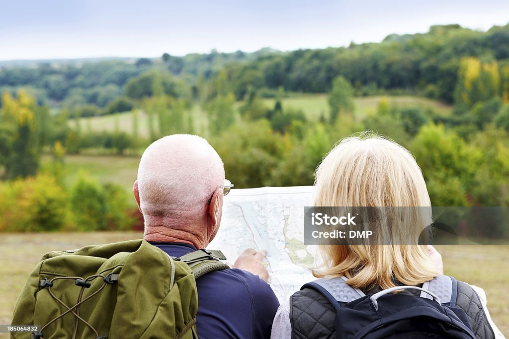 Pareja madura excursionismo mirando el mapa para obtener indicaciones para llegar - Foto de stock de Actividad libre de derechos