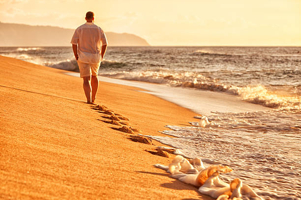 solitaire homme marchant sur la plage d'hawaï - shorts rear view summer beach photos et images de collection
