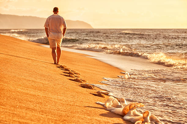 pojedyncza man walking na hawajska plaża - men footprint beach sunset zdjęcia i obrazy z banku zdjęć