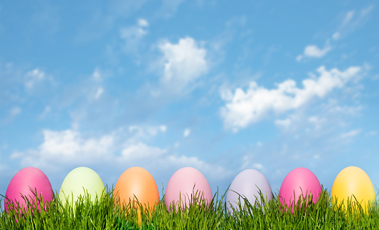 Easter Eggs In Green Grass on a Blue Sky.
