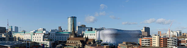 Birmingham skyline panorama "View of the Birmingham skyline on a clear sunny afternoon. A jumble of architectural styles, the Victorian architecture of St Martin's in the Bull Ring church contrasts with the curved 21st Century exterior of Selfridges department store on the right. As well as the Bullring shopping centre the panorama takes in restaurants, residential flats, car parks, hotels, offices and an outdoor market." birmingham england photos stock pictures, royalty-free photos & images