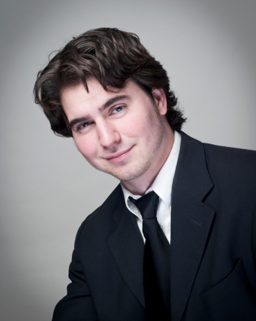Headshot of a young business man in a suit and tie.