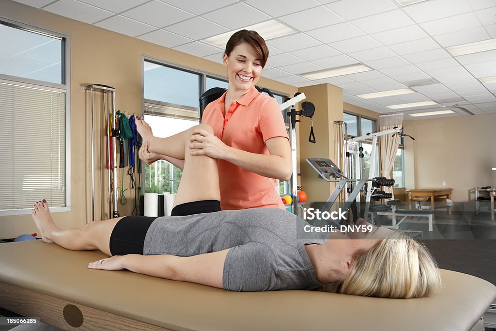 Fisioterapista e paziente in terapia fisica clinica - Foto stock royalty-free di Fisioterapia