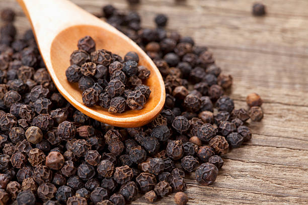 Black pepper close up of black peppercorn in wooden teaspoon; Adobe RGB color space; see other similar images: black peppercorn photos stock pictures, royalty-free photos & images