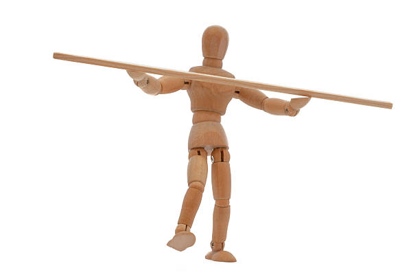 Wooden Mannequin balancing with a stack.