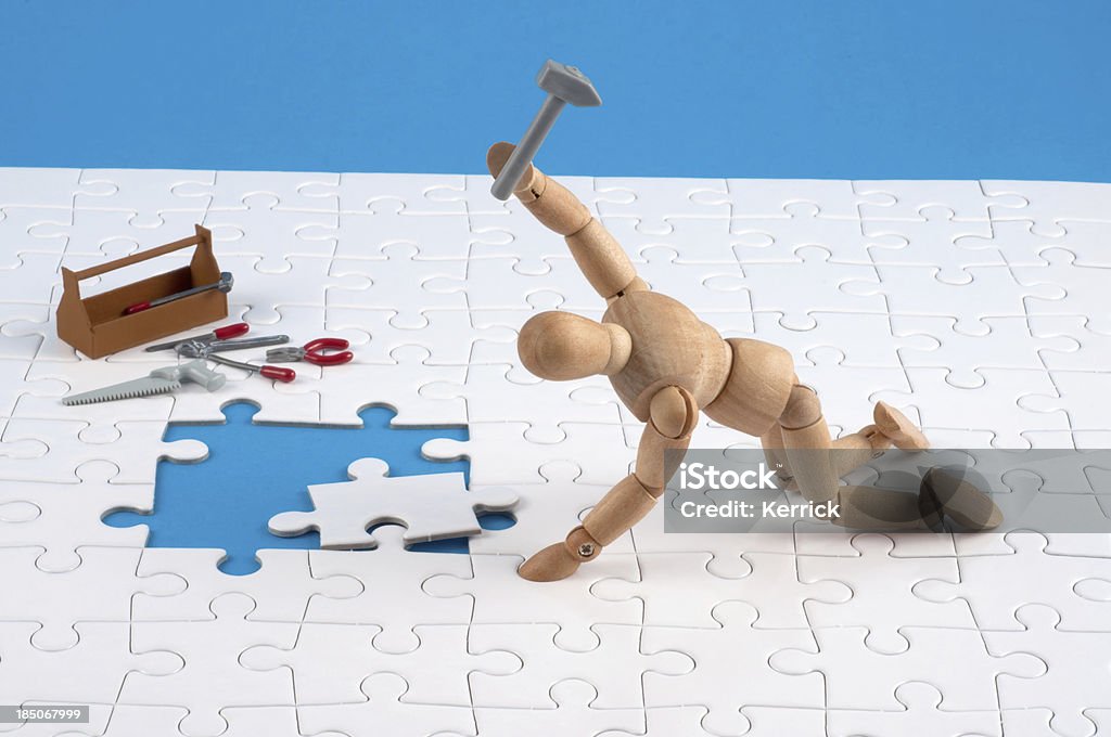 Hölzerne Kleiderpuppe arbeiten hart an einem Puzzle. - Lizenzfrei Puzzle Stock-Foto