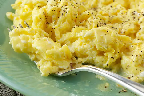 Photo of Fresh scrambled eggs on green plate