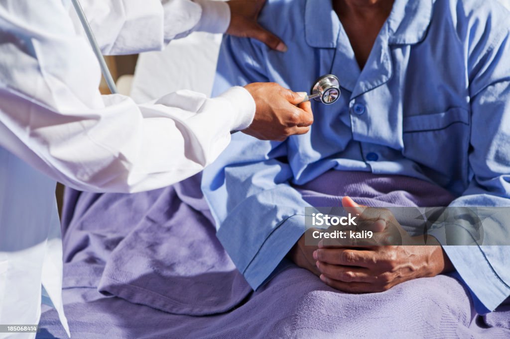 Médecin tenant Stéthoscope et patient à l'hôpital lit - Photo de Adulte libre de droits