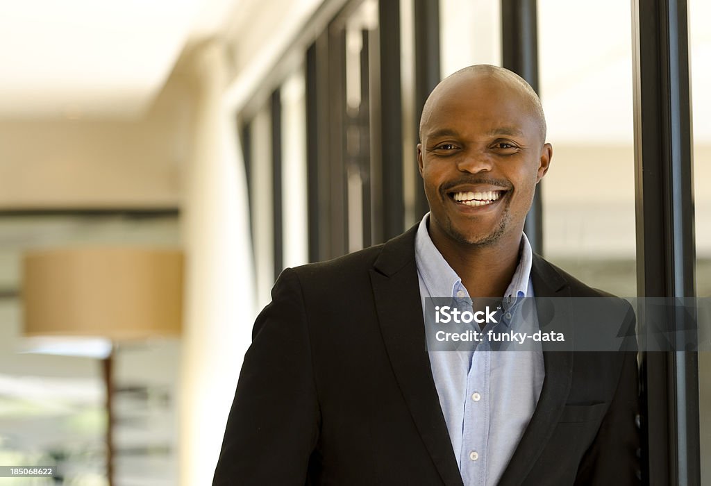 Cheerful African male Single cheerful African male leaning on the window and smiling.See also 20-29 Years Stock Photo