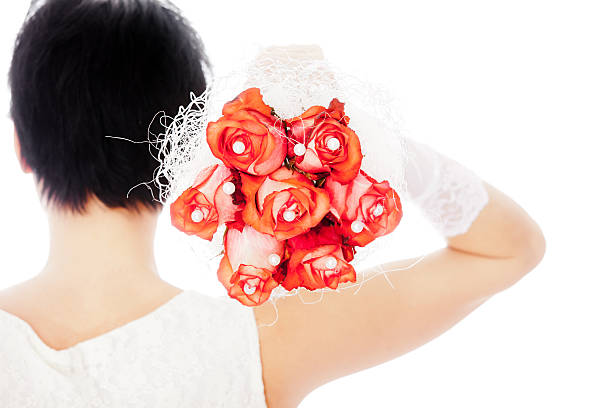 Young bride throwing a bouquet. Very bright backlit.