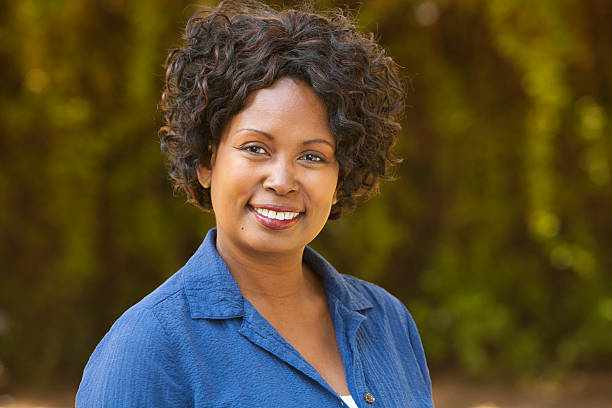 Portrait of an African American woman in front of foliage stock photo